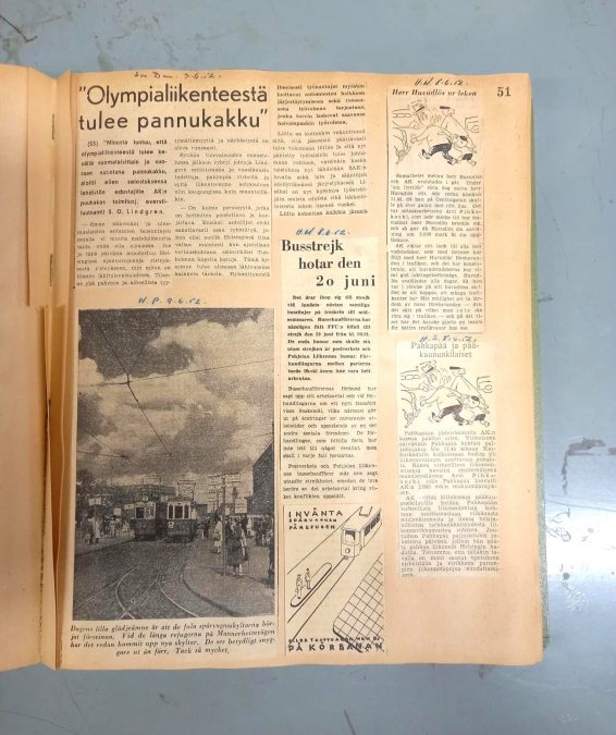 Metallisella pöydällä on avattu kellastunut sivu, joka on oikea puolisko sidoksen aukeamasta. Sivulle on liimattu kolme lehtileikettä, jotka käsittelevät kaupunkiliikenteeseen liittyviä asioita vuodelta 1952. Vasemmassa yläreunassa olevassa otsikossa lukee "Olympialiikenteestä tulee pannukakku"